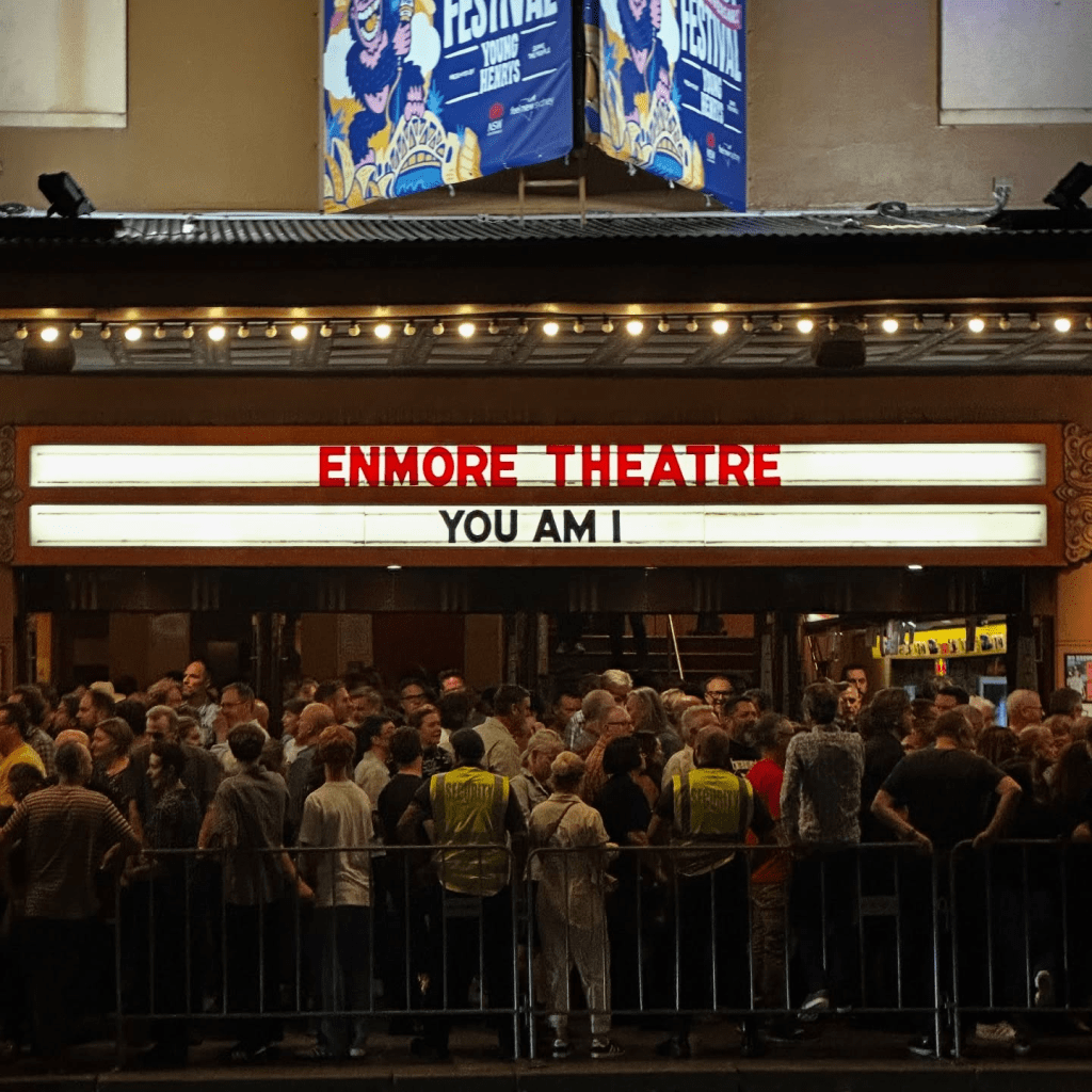 The marquee of The Enmore Theatre, Sydney, with YOU AM I displayed above a crowd of people. 